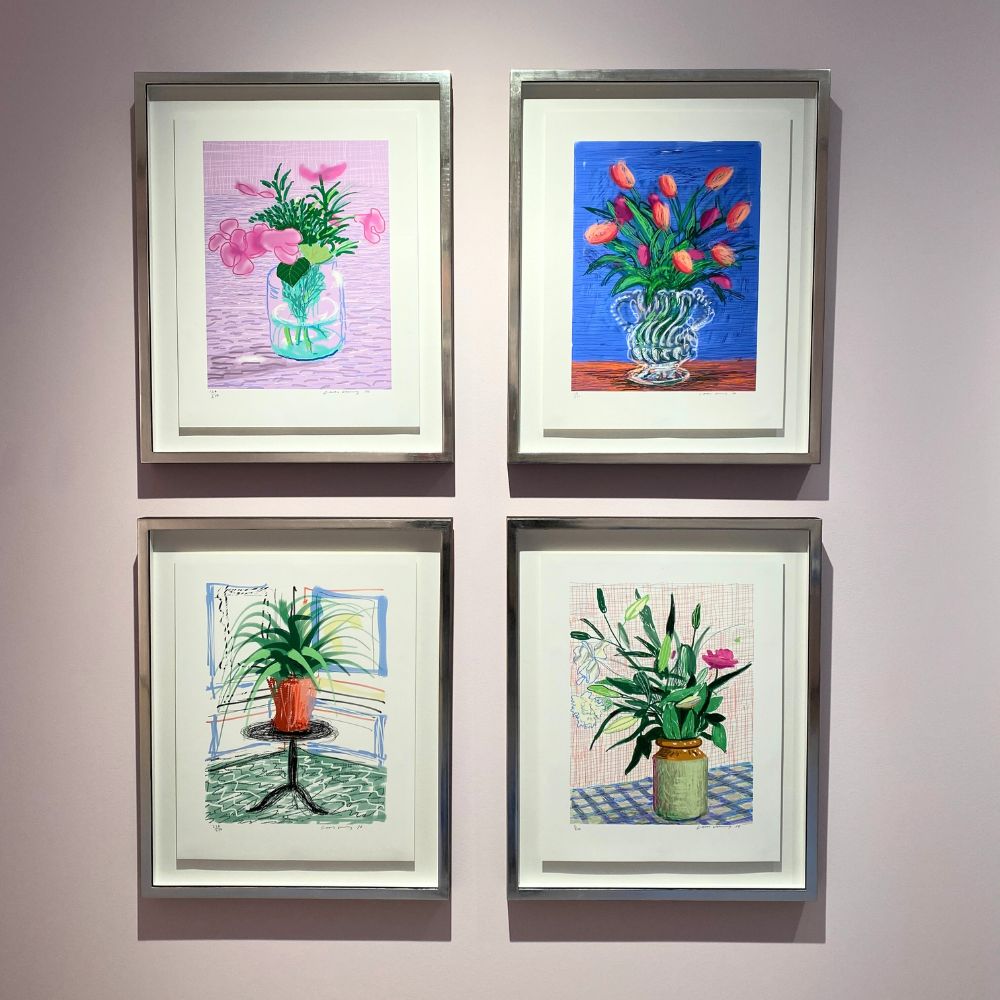 David Hockney framed ipad paintings on wall in the gallery colourful flowers and still life