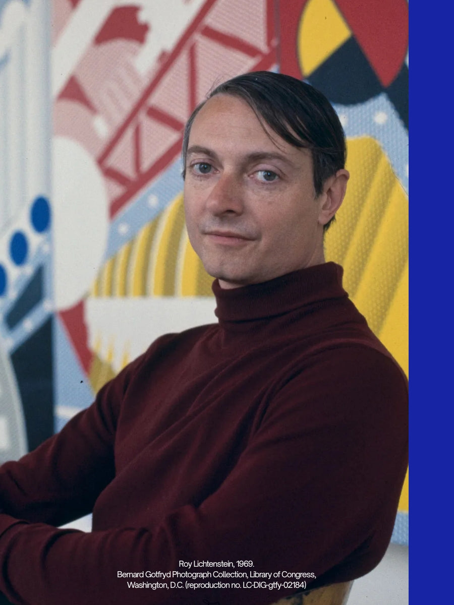 A portrait of artist Roy Lichtenstein in 1969, wearing a dark burgundy turtleneck sweater, seated in front of a colorful abstract mural. The photo is presented with a blue border on the right and a small caption at the bottom.