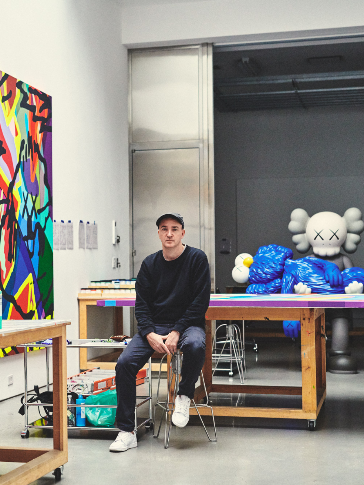  KAWS artist in his studio with paintings and sculpture