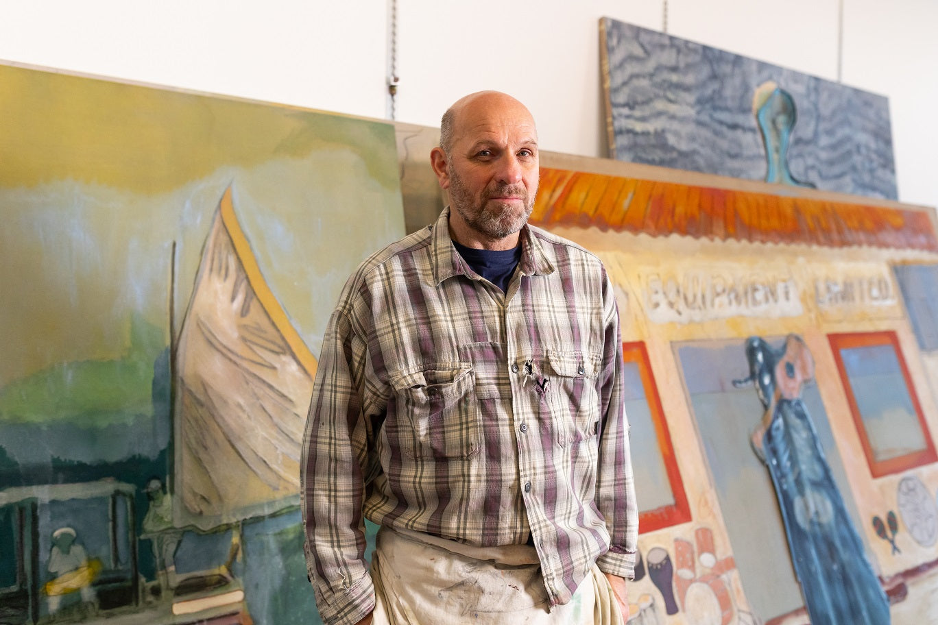 Peter Doig pictured in studio in front of paintings