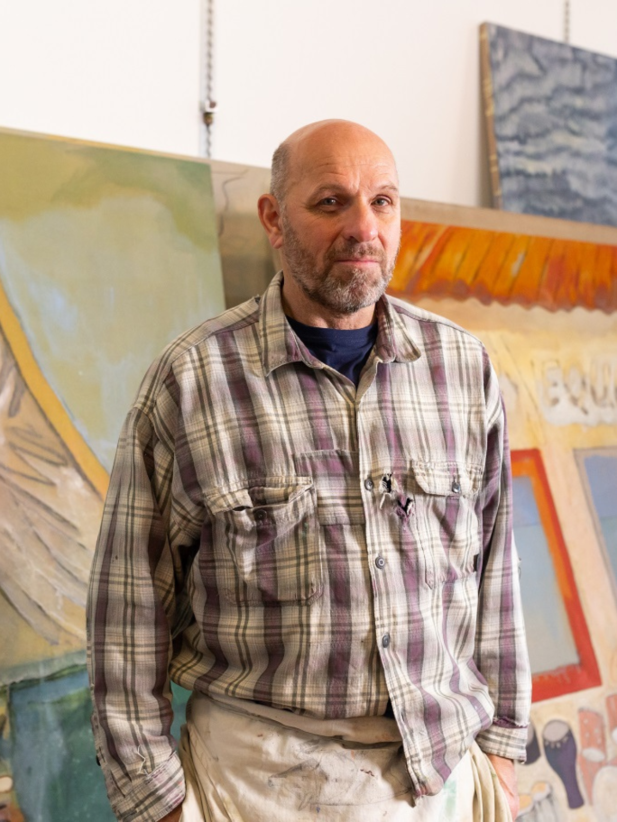 Peter Doig in studio with paintings